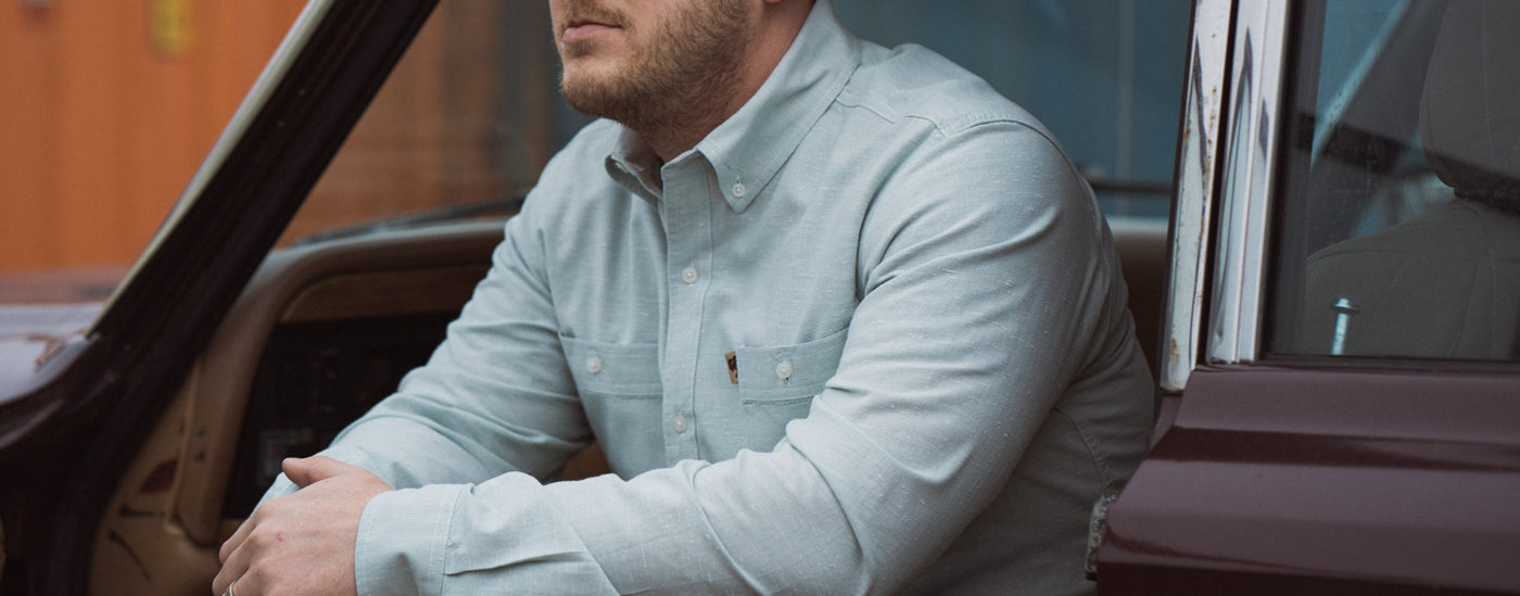 A man wears a short-sleeved chambray button down shirt from Buffalo Jackson.