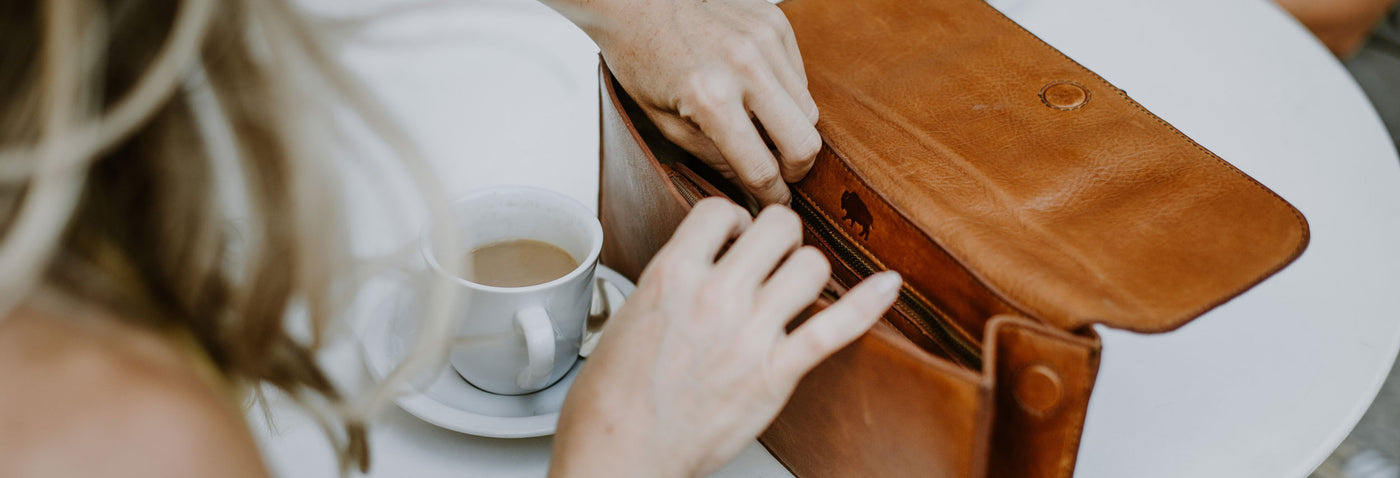 A woman opening a pocketbook.