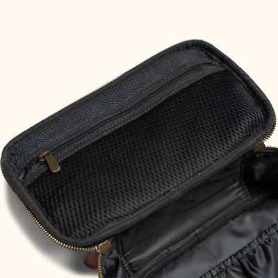 Open view of a dual-textured dopp kit, combining a breathable black mesh upper and a luxurious brown leather lower compartment, perfect for travel essentials.