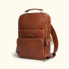 Unisex Commuter Leather Backpack- Elegant brown leather backpack with top handle, front pocket, and side zippers, perfect for professional and casual use.