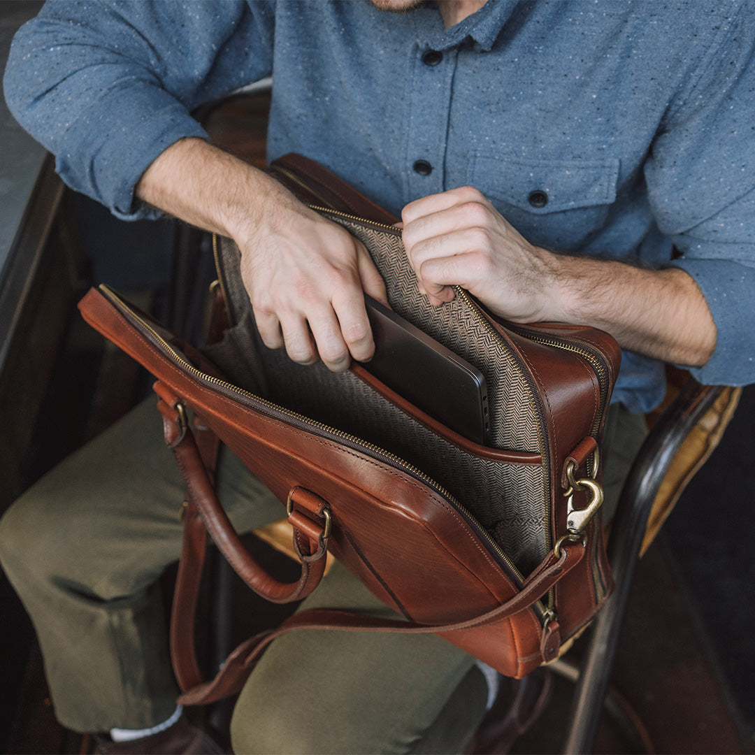 High-quality tan leather briefcase with spacious interior, suitable for laptops and documents.