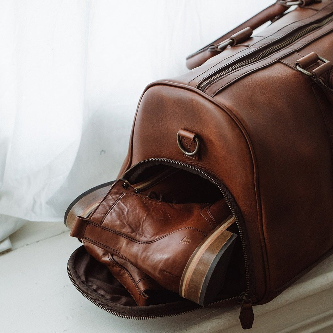Sophisticated leather carryall, ideal for travel, with ample space, secure zippers, and a timeless design.