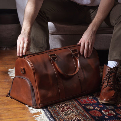 Sophisticated leather carryall, ideal for travel, with ample space, secure zippers, and a timeless design.