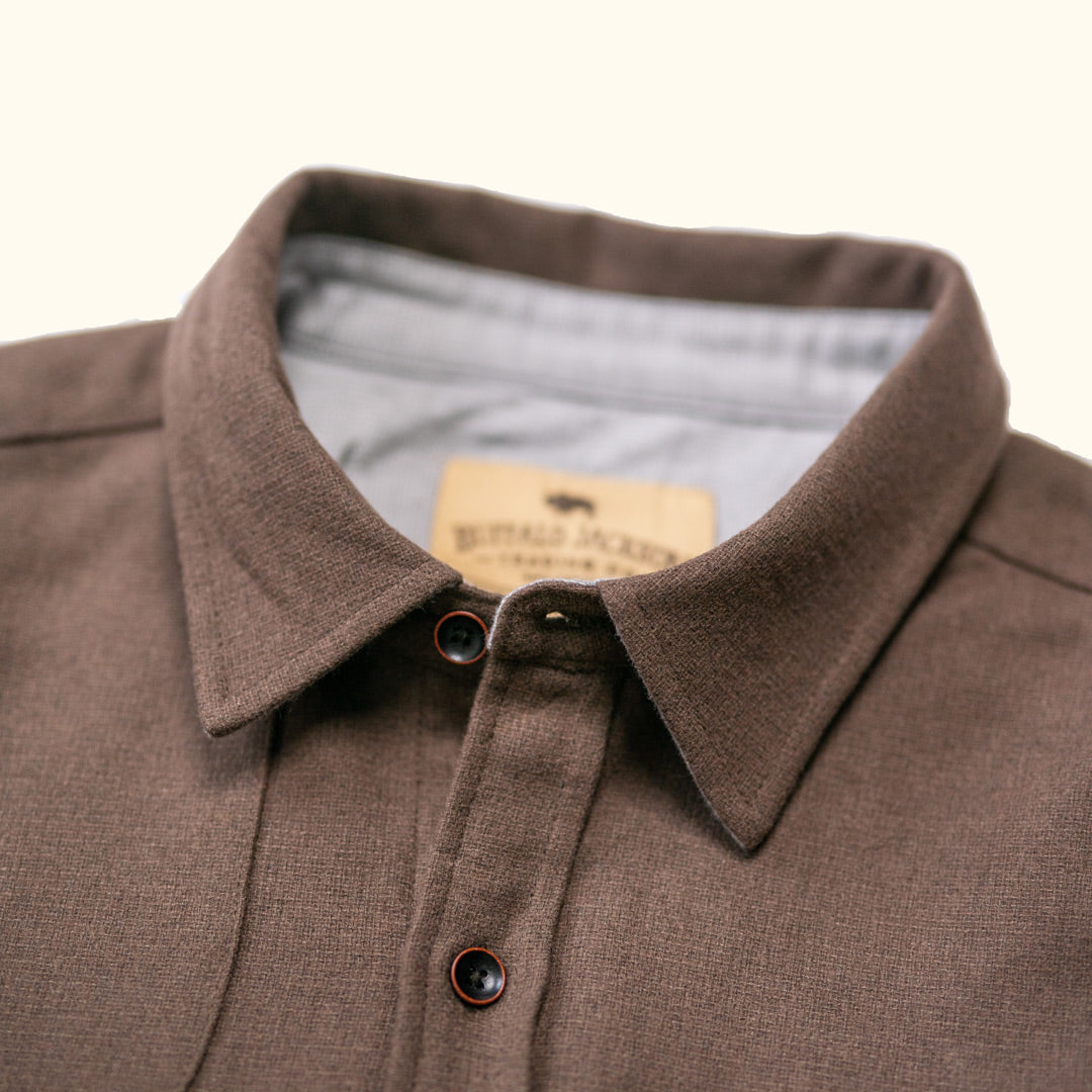 Close-up of collar and button placket on Gunnison brown wool-blend solid flannel showing wood-tone buttons and clean stitching