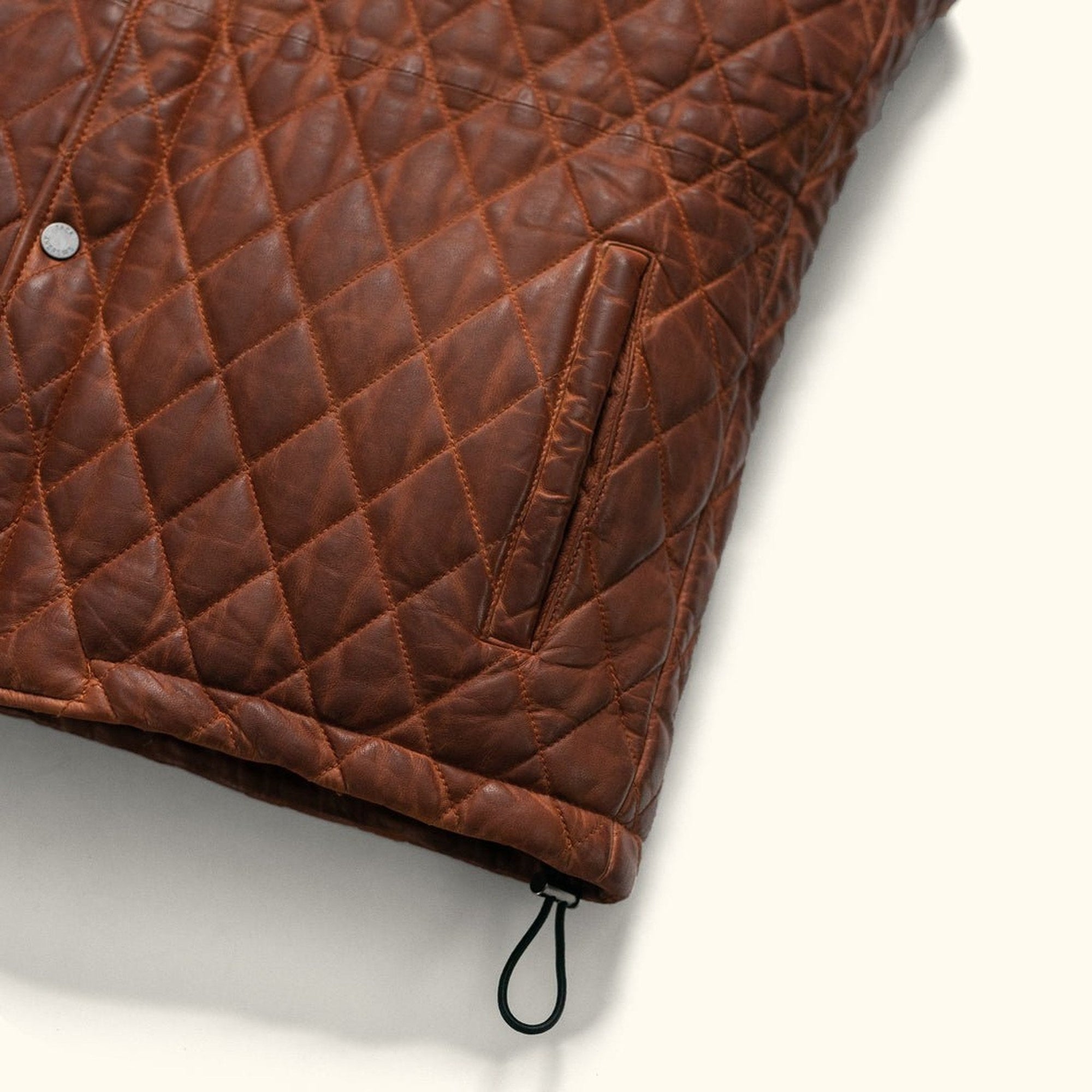 Highlands Quilted Leather Vest in Whiskey Brown, hem toggle detail.