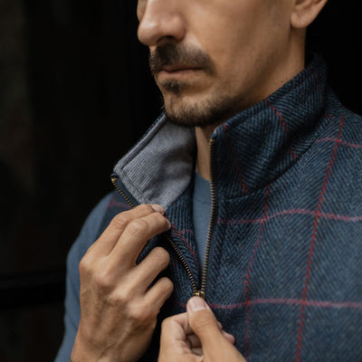 Close-up of the Ashton Wool Herringbone Vest in Clan Blue: zip pull and red windowpane check