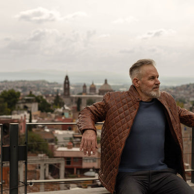 Man on a city rooftop in the Highlands Quilted Leather Jacket in Whiskey Brown.