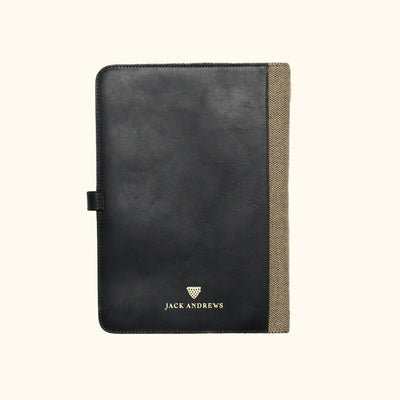 Black leather notebook with beige corner on a white background