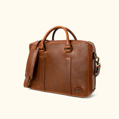 Executive-style tan leather briefcase, featuring a smooth exterior and robust carrying options.