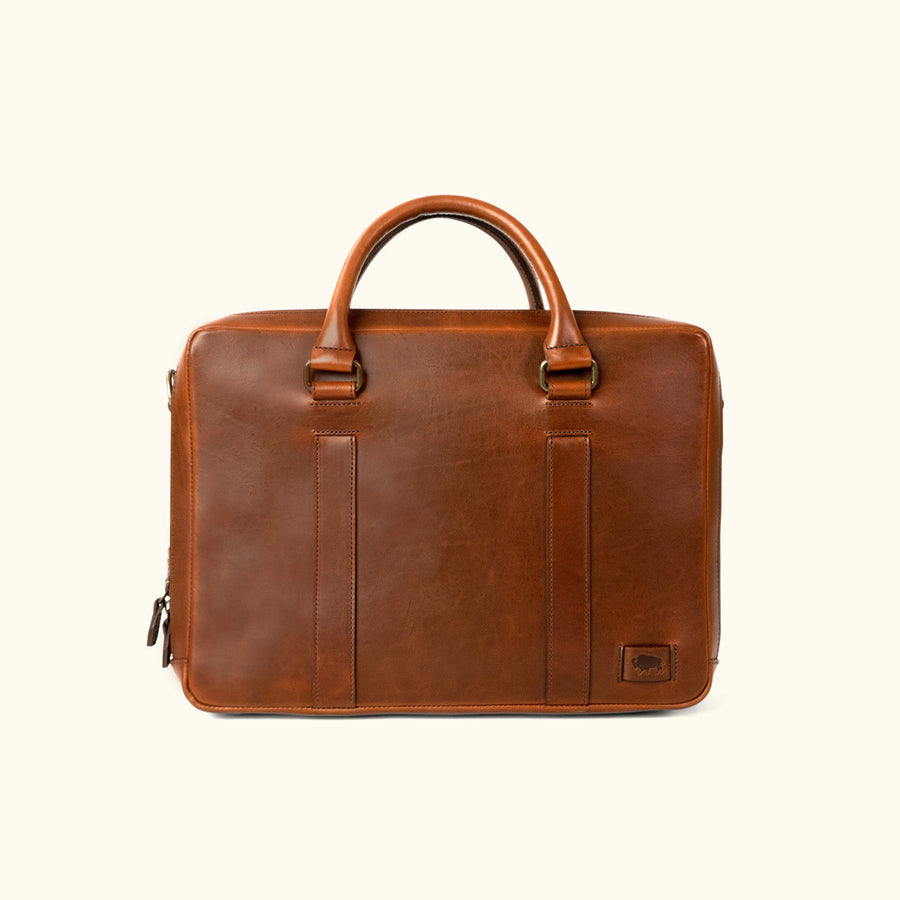 Executive-style tan leather briefcase, featuring a smooth exterior and robust carrying options.