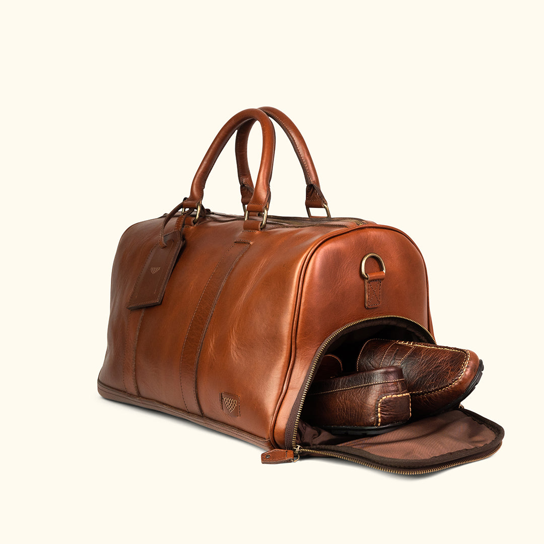 High-quality leather duffle with robust carry handles, adjustable shoulder strap, and large zippered opening.