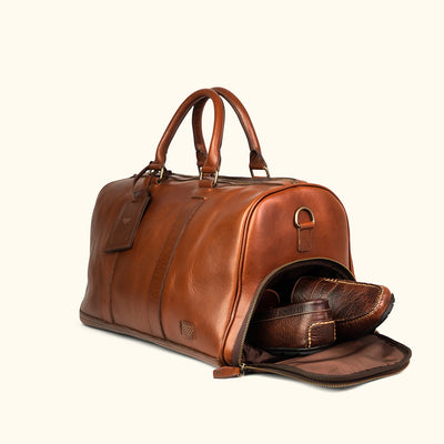 High-quality leather duffle with robust carry handles, adjustable shoulder strap, and large zippered opening.