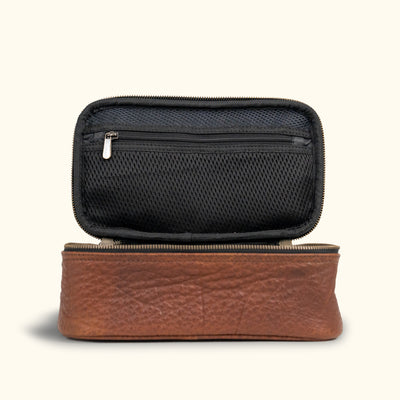 Stylish two-tone dopp kit with a black mesh top and rich brown leather base, featuring a sleek zipper for secure closure.