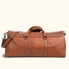 Rustic brown leather travel bag, featuring old-fashioned buckle closures and a versatile shoulder strap for outdoor excursions.
