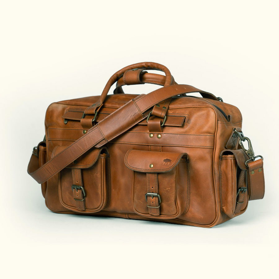 Roosevelt’s amber brown buffalo leather bag, perfect for travel with robust straps and several organizational pockets.