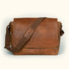 Large amber brown buffalo leather satchel messenger bag with adjustable canvas strap and smooth finish.