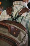 Close-up of a leather-strapped backpack with metal hardware, highlighting craftsmanship and durability.