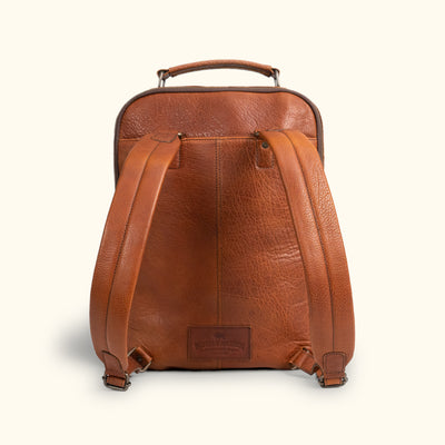 Rear view of a textured brown leather backpack with sturdy, adjustable straps and top handle for stylish, comfortable carrying.