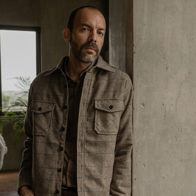 Man in the Aberdeen Wool Twill Shirt Jac in Thistle Grove leaning on a concrete column