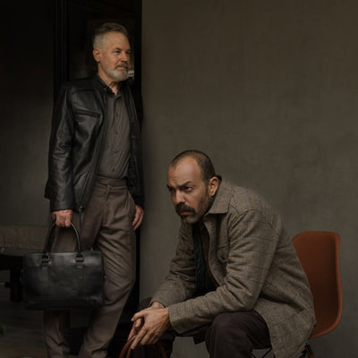 Seated man in the Aberdeen Wool Twill Shirt Jac in Thistle Grove with a leather briefcase