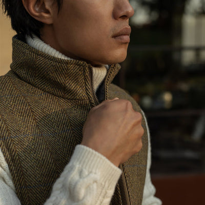 Hand at the stand collar of the Ashton Wool Herringbone Vest in Mosswood