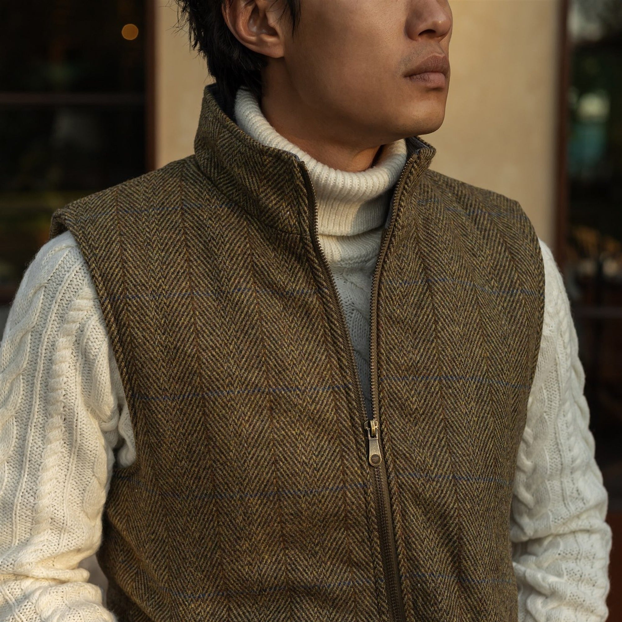 Ashton Wool Herringbone Vest in Mosswood worn over a cream turtleneck sweater