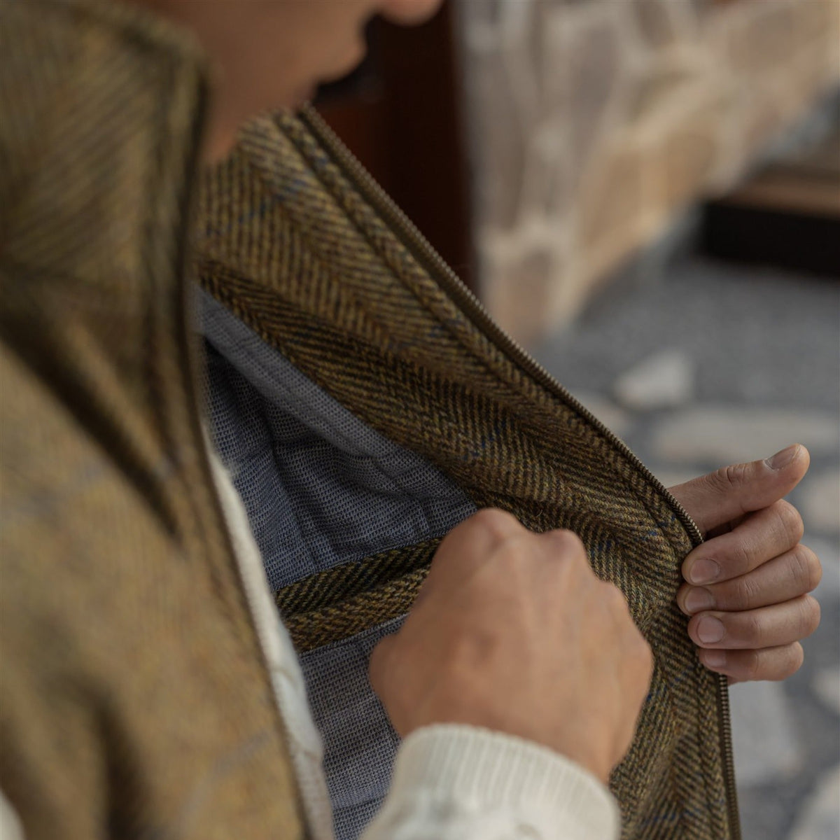 Opening the Ashton Wool Herringbone Vest in Mosswood to show the light blue quilted lining