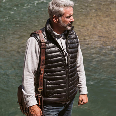 This premium black leather puffer vest showcases meticulous stitching and a robust zipper for a sleek, modern look.