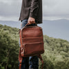Sleek brown leather backpack featuring multiple compartments, durable zippers, and adjustable straps, ideal for stylish, organized travel.