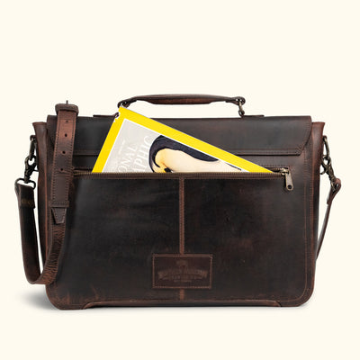 Antique-style dark brown leather satchel with brass hardware, secure turn-lock closure, and a distressed finish for a timeless appeal, pockets perfect to fit a magazine.