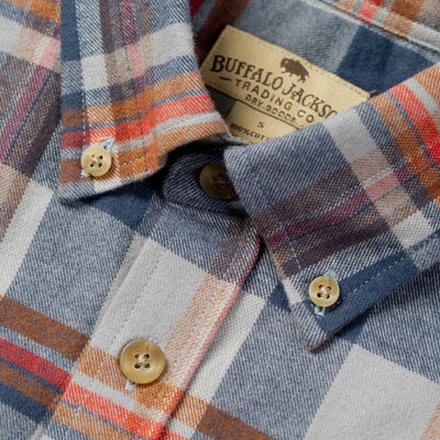 Plaid shirt with buttons and a visible brand label on a close-up of the collar.