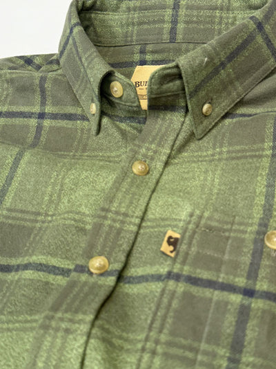 Close-up of a green plaid button-down shirt with brass buttons and a small embroidered logo patch on the chest pocket.