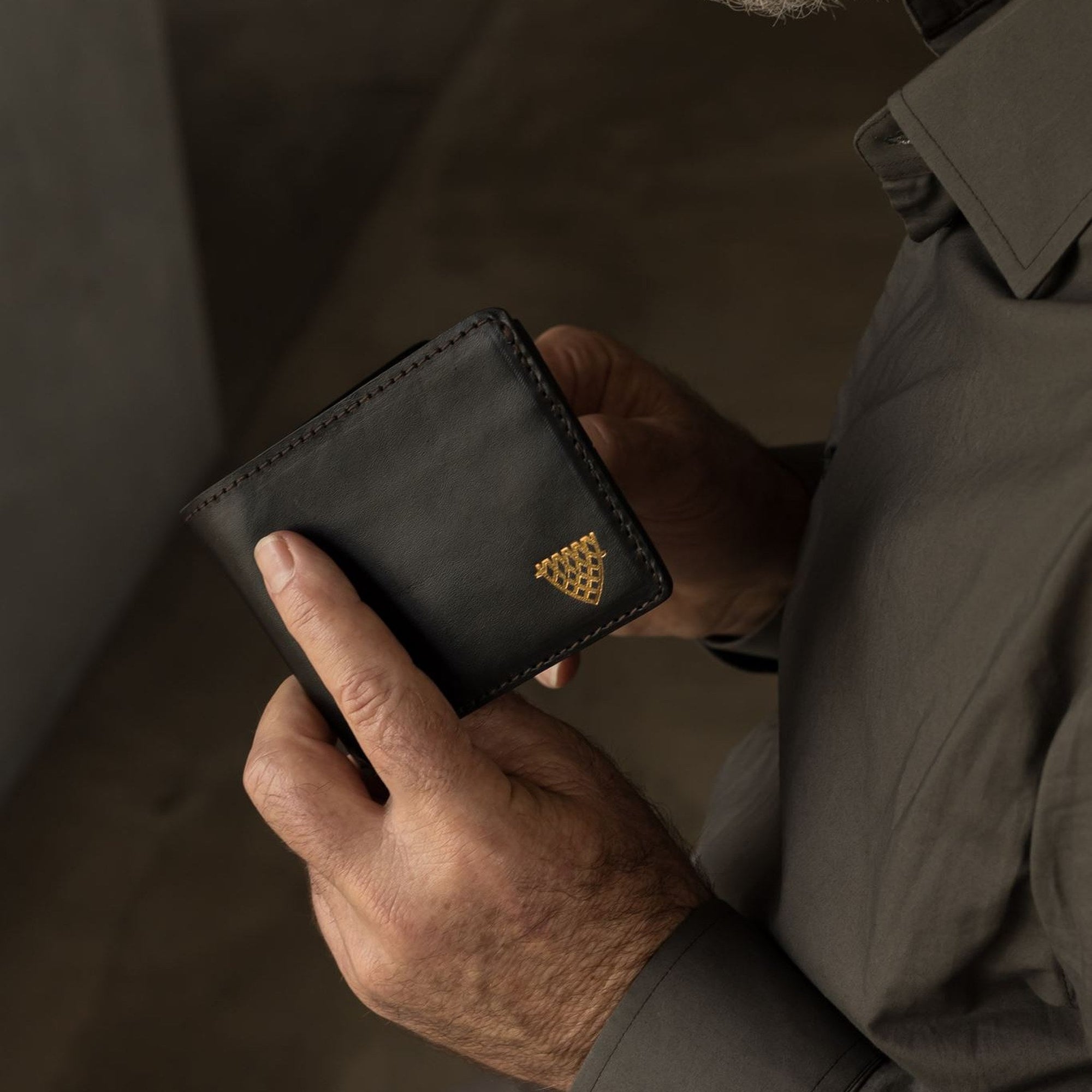Man holding the Jefferson Leather Bifold Wallet in Vintage Black.