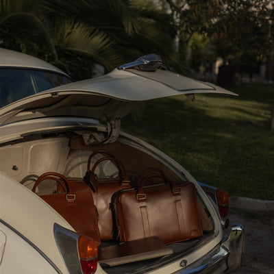 Jefferson Leather Duffle in Elderwood Brown with the Jefferson collection packed in a vintage car trunk.