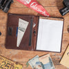 Sophisticated buffalo grain leather travel organizer padfolio with pen loop, card holders, and ID window for professionals.