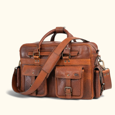 Classic distressed leather carryall with spacious compartments, front flap pockets, and a sturdy detachable strap for versatile carrying options.