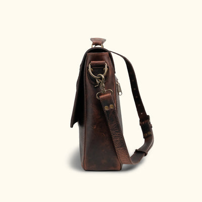 Side Angle - Distressed leather messenger bag featuring a rich dark brown hue, ample storage compartments, and an adjustable shoulder strap for versatile use.