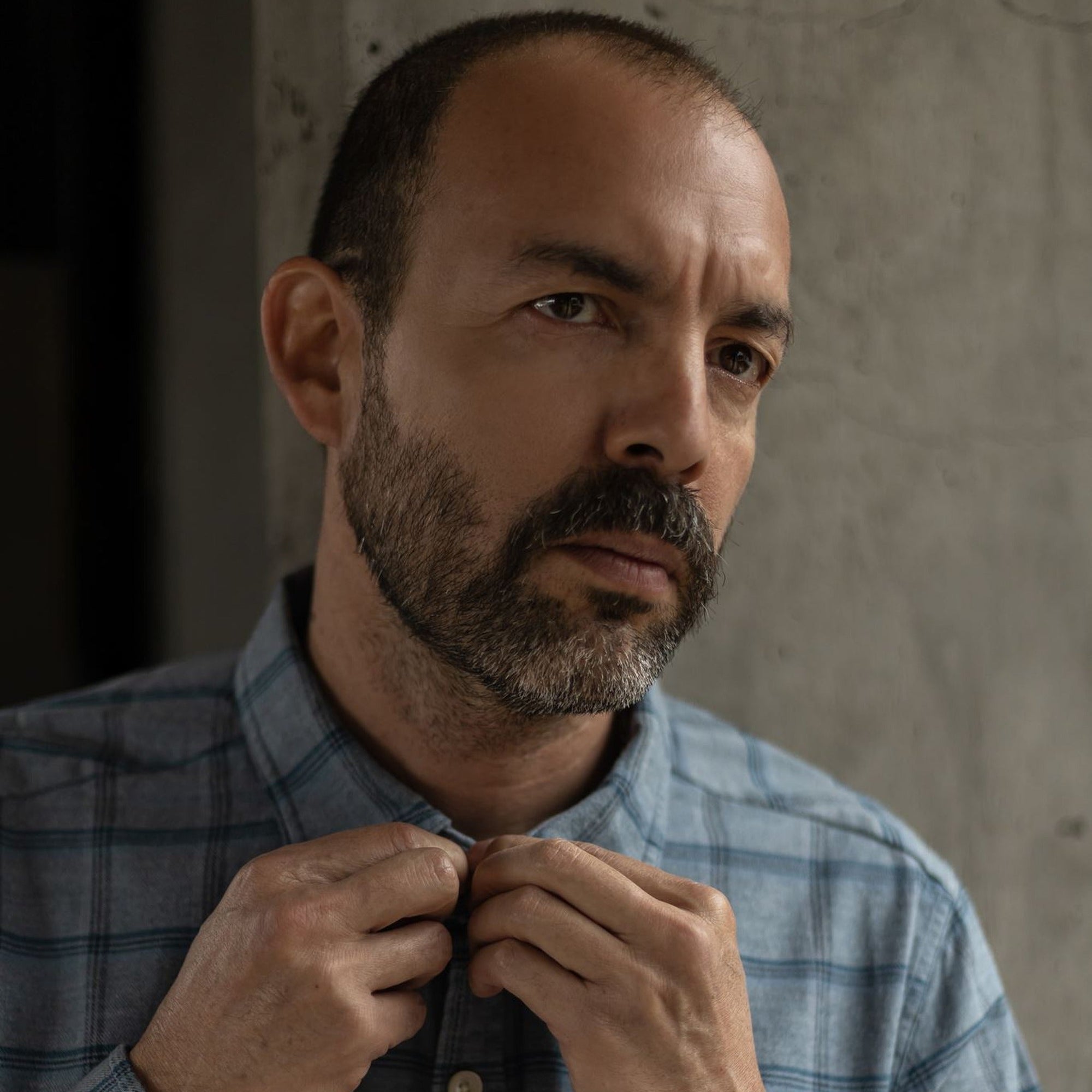 Man buttoning the collar of the Windsor Cotton Shirt in Sky Pane