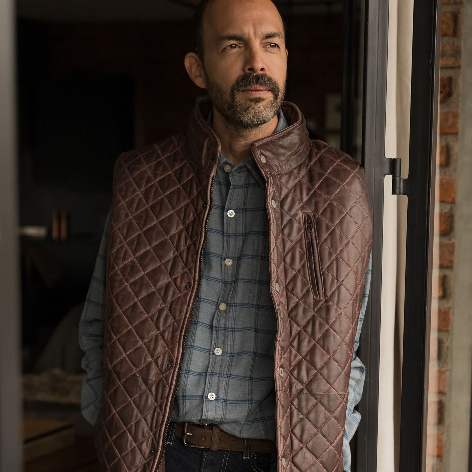 Man in a doorway wearing the Windsor Cotton Shirt in Sky Pane under a quilted leather vest