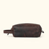 Sleek Roosevelt travel toiletry bag in dark oak leather with a minimalist, functional design.