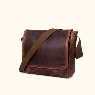 Richly toned dark oak leather satchel featuring a sturdy build, spacious interior, and secure flap closure for stylish organization.