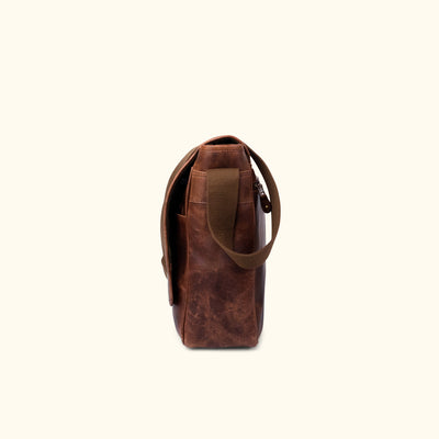 Side Angle | Luxury dark oak leather messenger with a minimalist design, featuring precise stitching and a comfortable, adjustable canvas strap for easy carrying.
