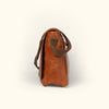 Stylish amber brown leather messenger bag with durable stitching and practical design.