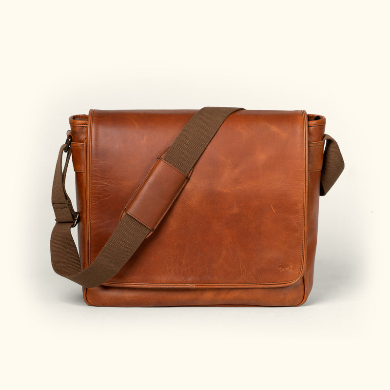 Roosevelt leather satchel in amber brown with a crossbody strap and classic silhouette.