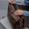 Large leather messenger bag with spacious main compartment and secure zipper, ideal for work essentials and daily items.