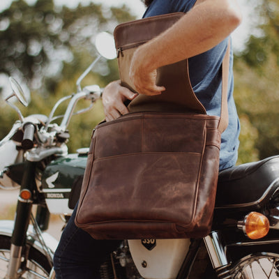 Dark walnut leather satchel, adjustable strap, top flap, rear zipper pocket, vintage style, modern practicality.