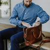 Stylish man accessing contents of a sophisticated leather attache bag. Men's Best Leather Attache | Elderwood hover