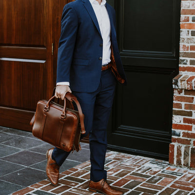 Stylish tan leather briefcase, seamlessly matching business attire, with elegant lines and polished hardware for a sophisticated look.