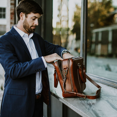 Artisan-crafted leather briefcase in warm tan, equipped with sturdy handles and detachable shoulder strap.