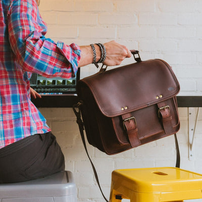 Professional dark oak buffalo leather camera bag with reinforced corners and classic buckle fastenings.